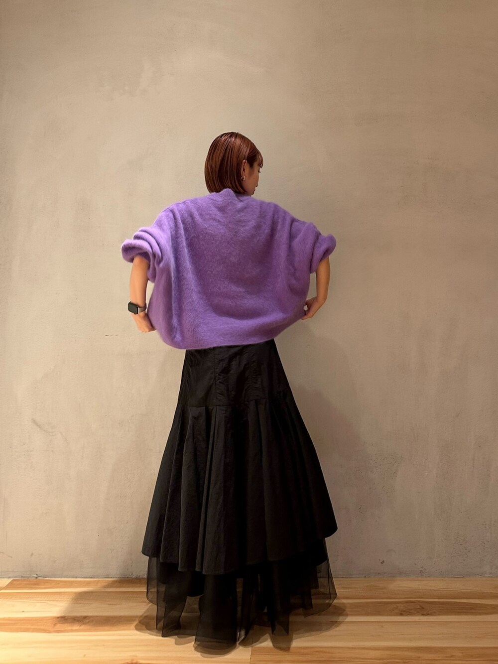 ブラック系のスカート、パープル系のニット/セーター、ブラック系のブーツを着用したレディースの秋コーディネートの5枚目の写真