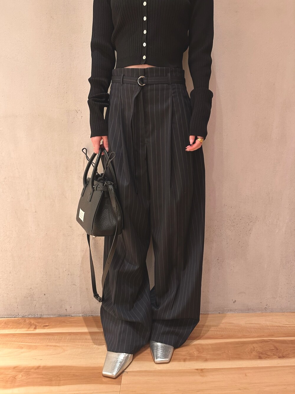 ブラック系のカーディガン/ボレロ、ブラック系のショルダーバッグ、ブルー系のその他パンツを着用したレディースの春コーディネートの6枚目の写真