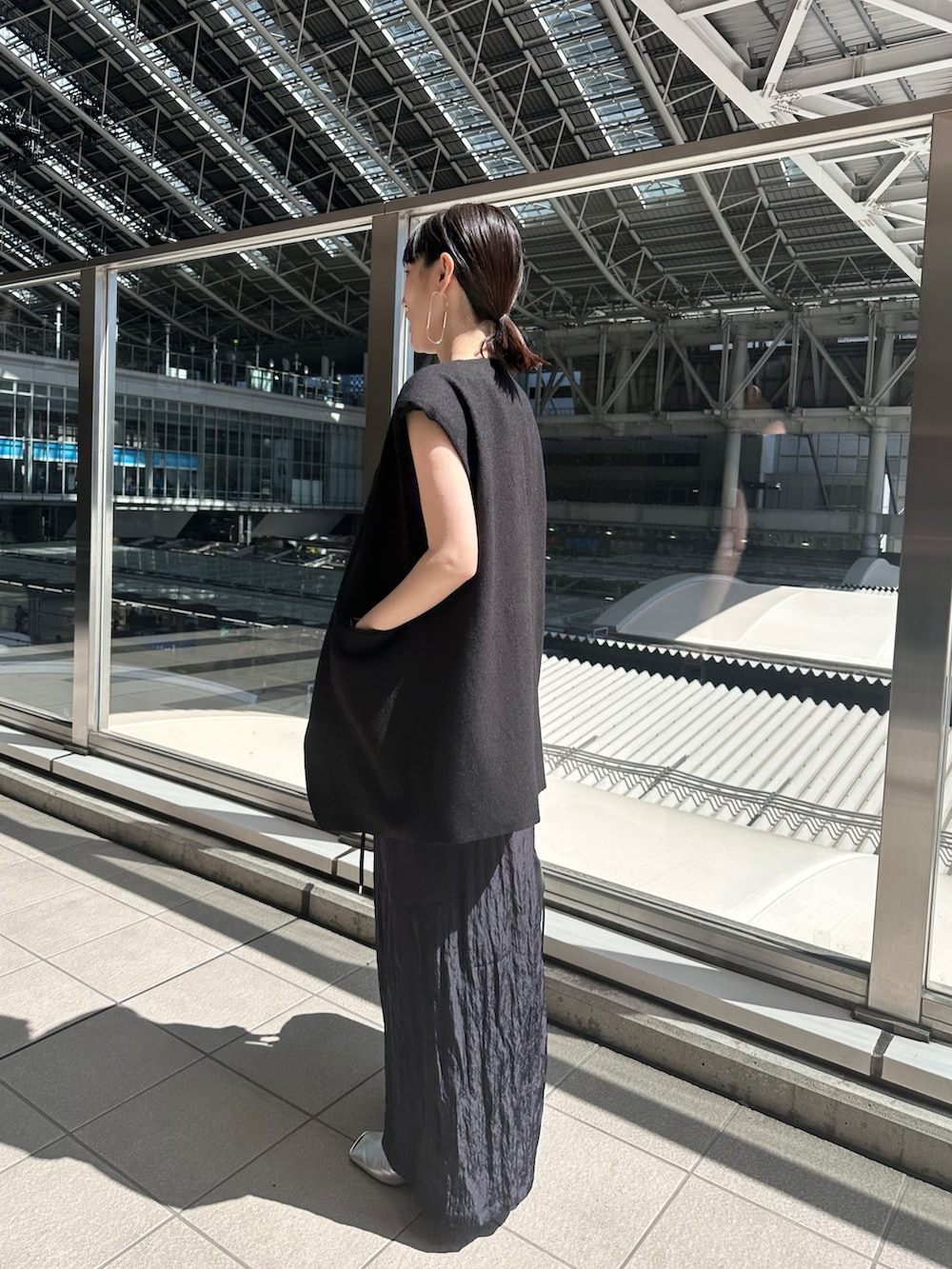 ブラック系のテーラードジャケット、ブルー系のスカート、シルバー系のパンプスを着用したレディースの春コーディネートの5枚目の写真