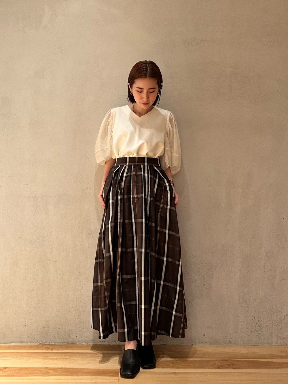 ホワイト系のTシャツ/カットソー、ブラウン系のスカート、ブラック系のパンプスを着用したレディースの春コーディネートの5枚目の写真