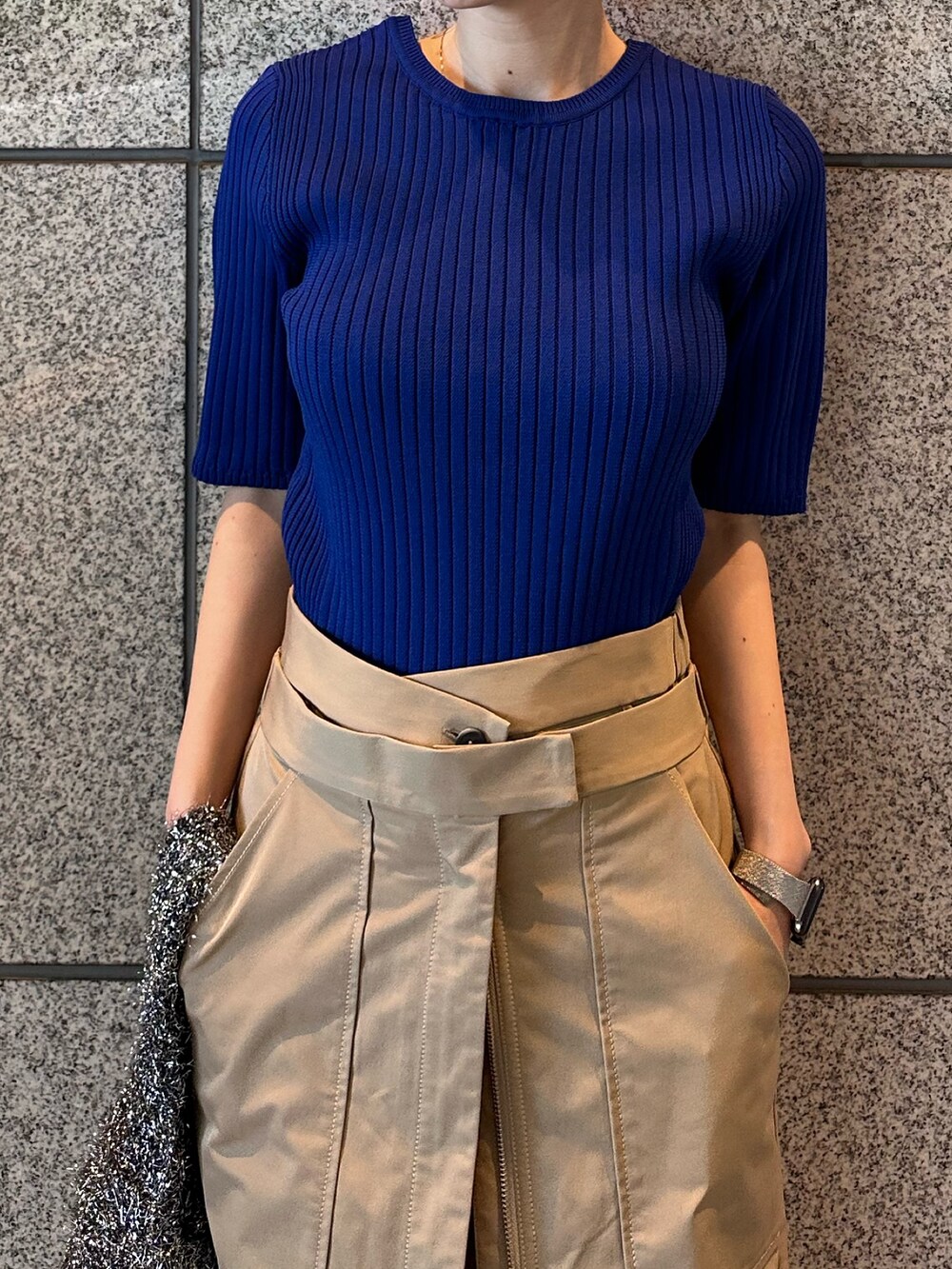 ブルー系のニット/セーター、ブラック系のノーカラージャケット、ベージュ系のスカートを着用したレディースの秋コーディネートの8枚目の写真