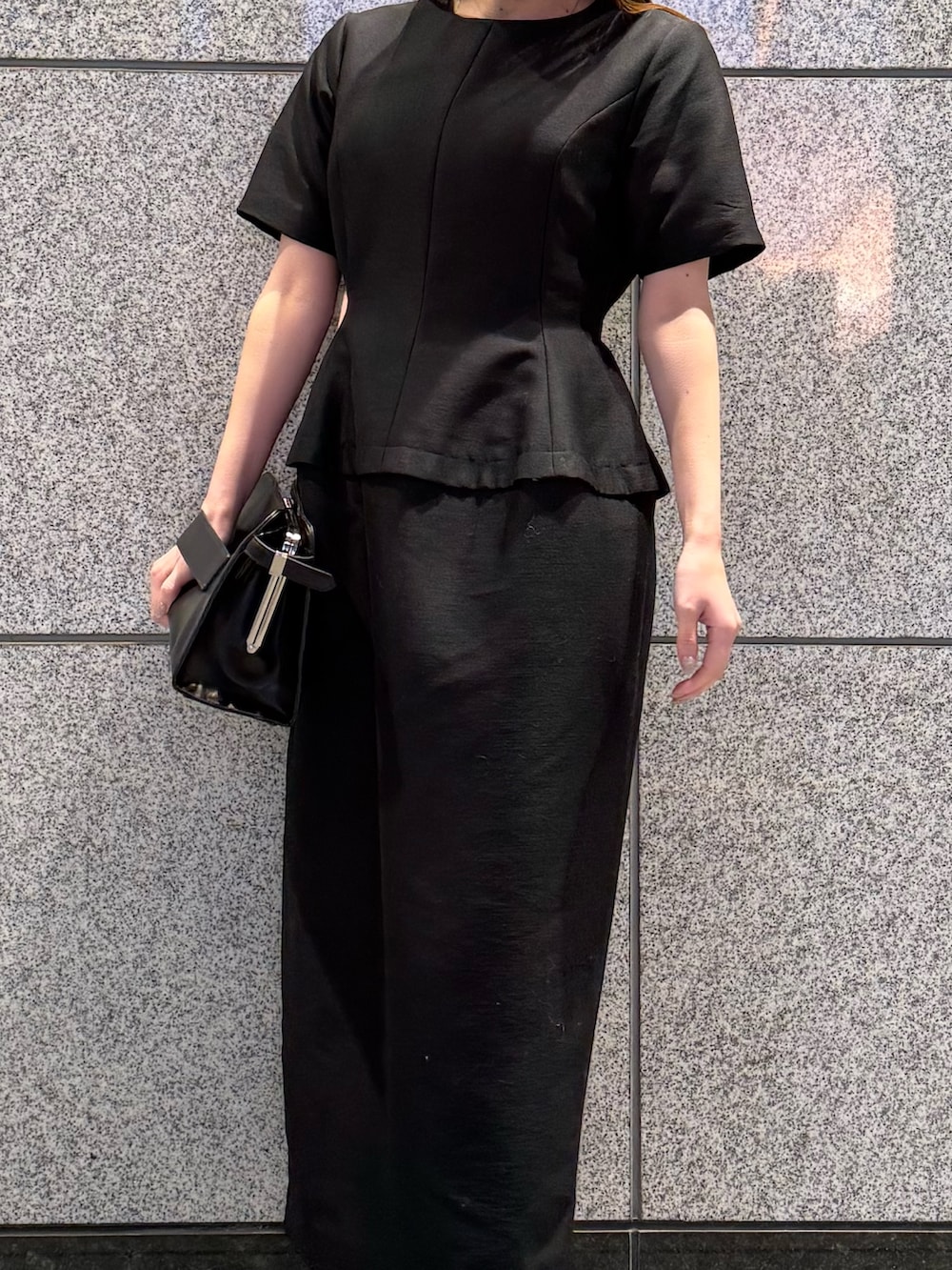 ブラック系のワンピース、ブラック系のハンドバッグを着用したレディースの冬コーディネートの5枚目の写真