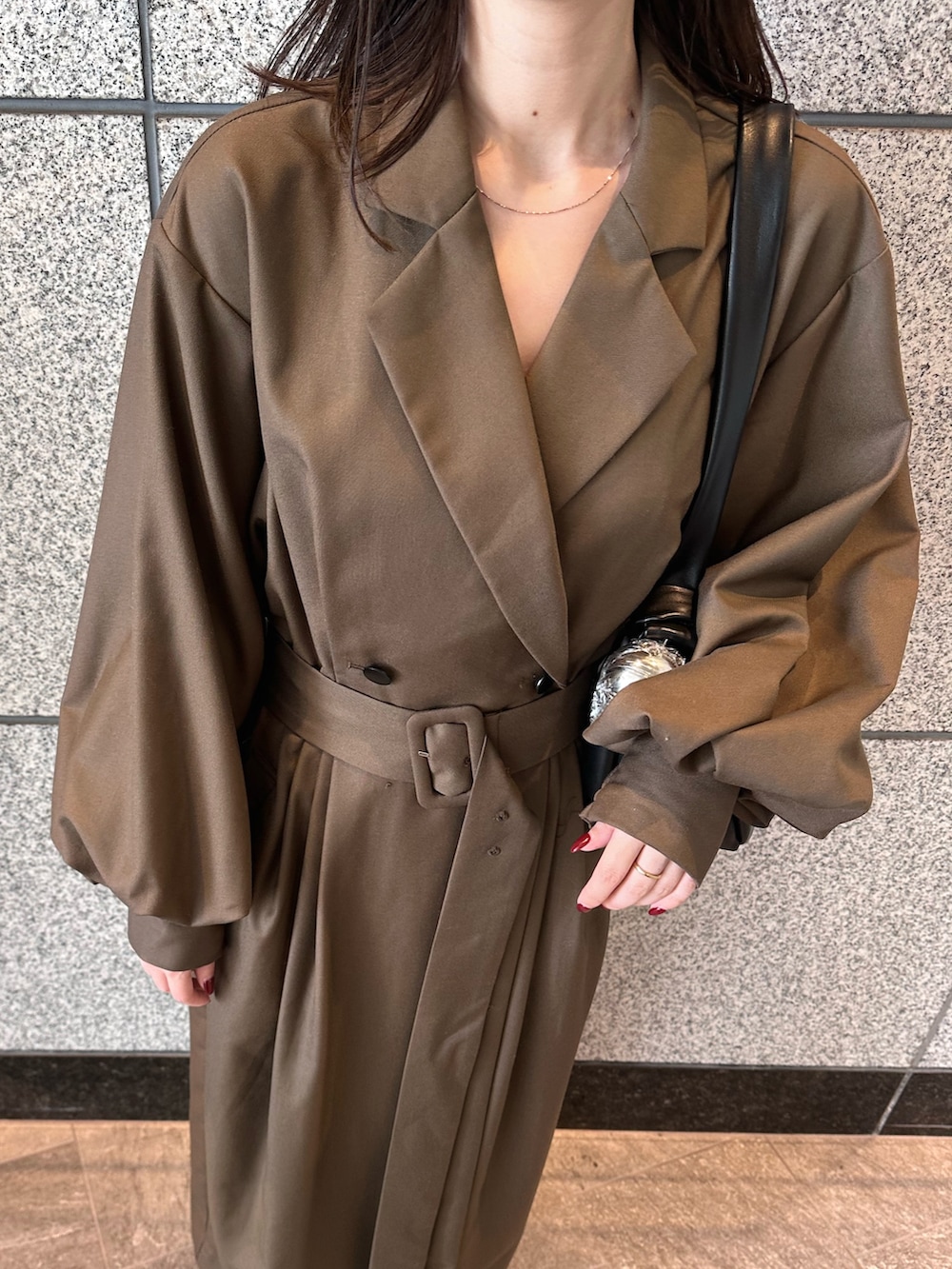 ブラウン系のワンピース、ゴールド系のブーツ、ブラック系のハンドバッグを着用したレディースの秋コーディネートの7枚目の写真