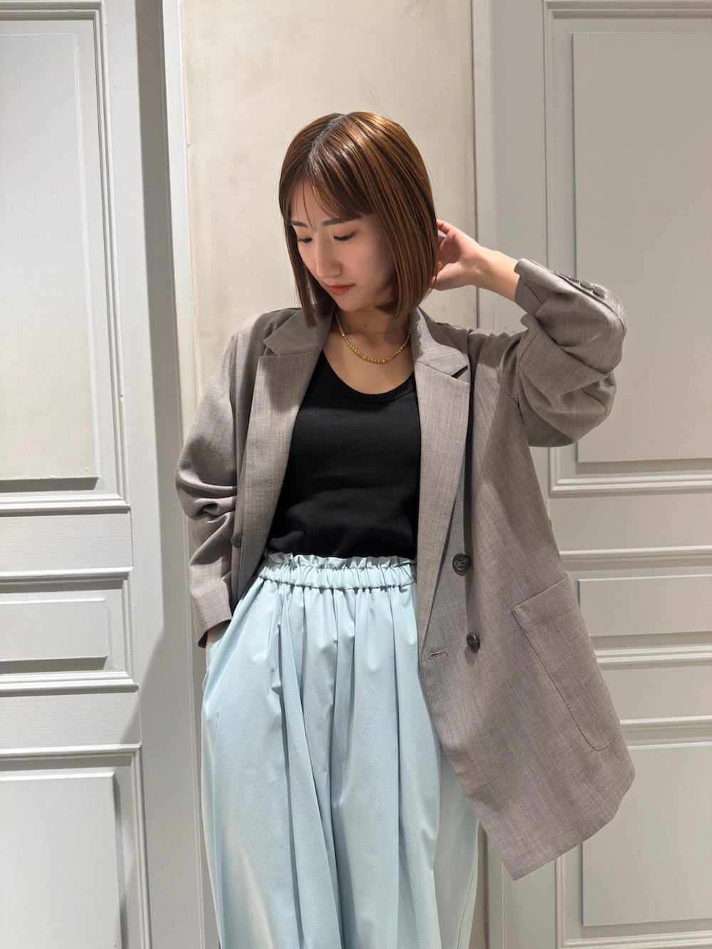 グレー系のテーラードジャケット、グリーン系のその他パンツ、シルバー系のパンプスを着用したレディースの冬コーディネートの3枚目の写真