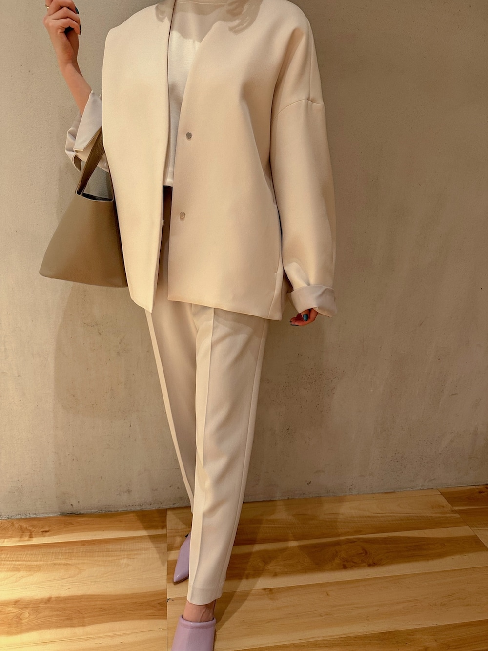 グレー系のその他パンツ、ベージュ系のハンドバッグ、ブラウン系のノーカラーコートを着用したレディースの冬コーディネートの3枚目の写真