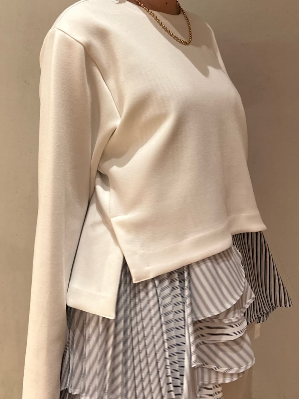 ホワイト系のスニーカー、ブラック系のハンドバッグ、グレー系のその他パンツを着用したレディースの冬コーディネートの4枚目の写真