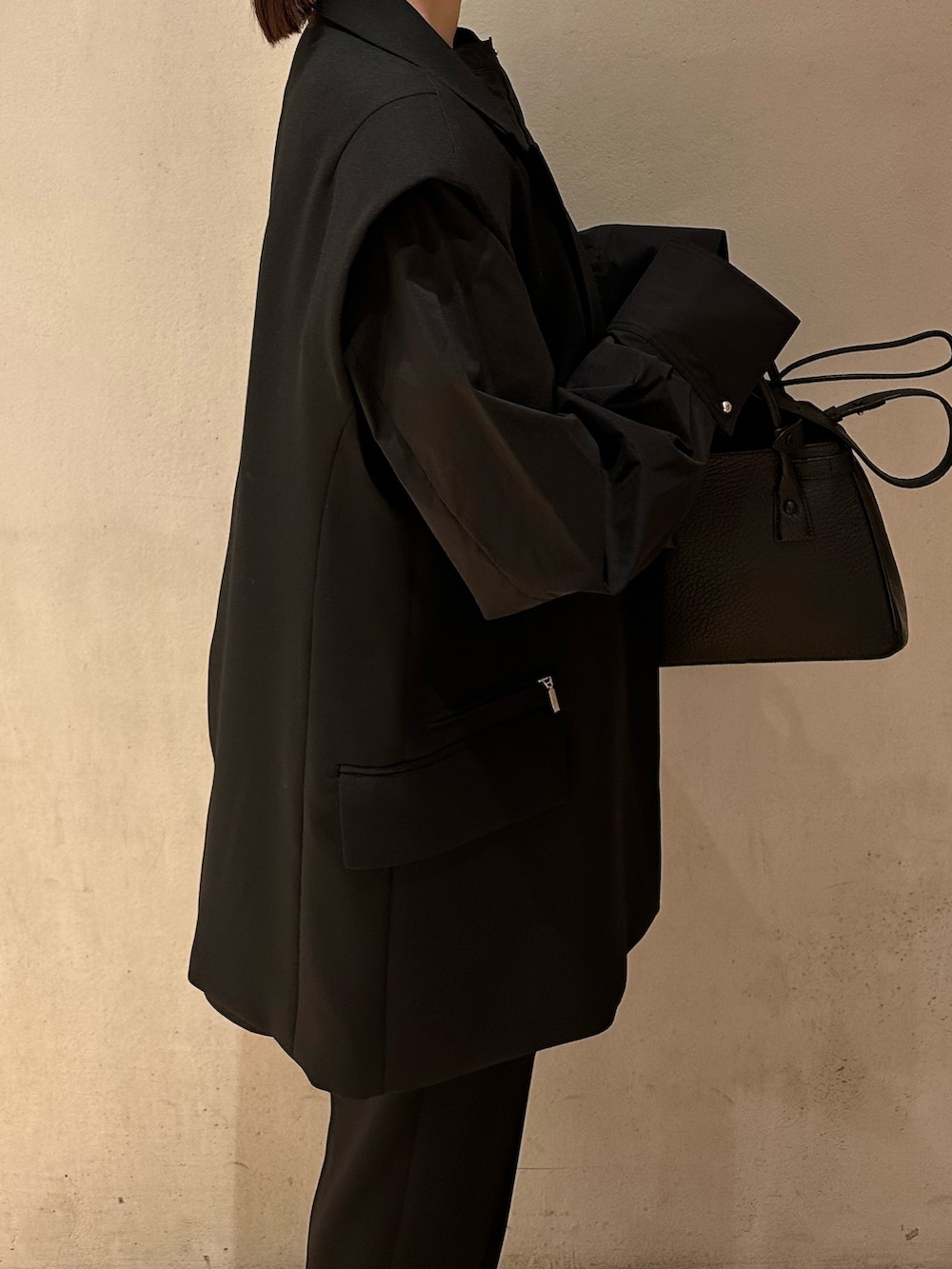 ブラック系のショルダーバッグ、ブラック系のテーラードジャケット、ブラック系のその他パンツを着用したレディースの春コーディネートの5枚目の写真