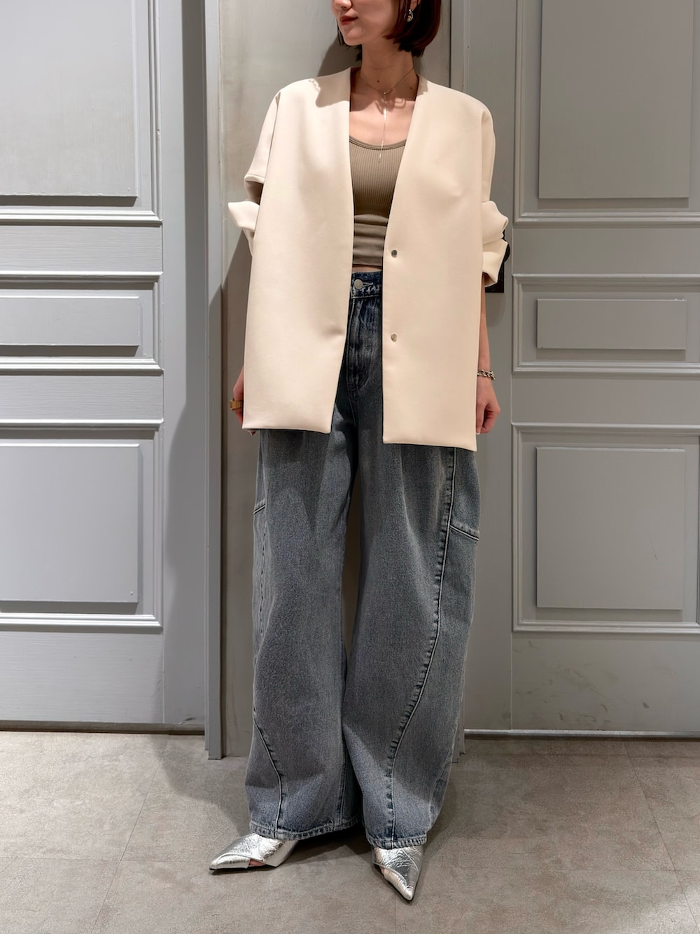 ベージュ系のその他アウター、ブルー系のデニムパンツ、シルバー系のパンプスを着用したレディースの春コーディネートの2枚目の写真