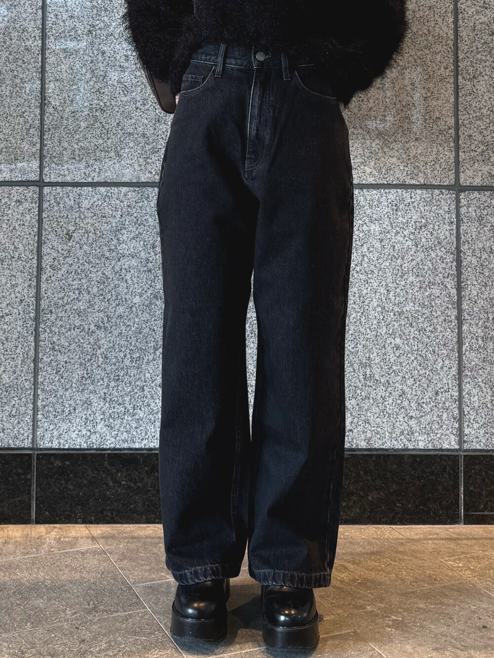 ブラック系のニット/セーター、ブラック系のデニムパンツ、ブラウン系のボストンバッグを着用したレディースの冬コーディネートの8枚目の写真