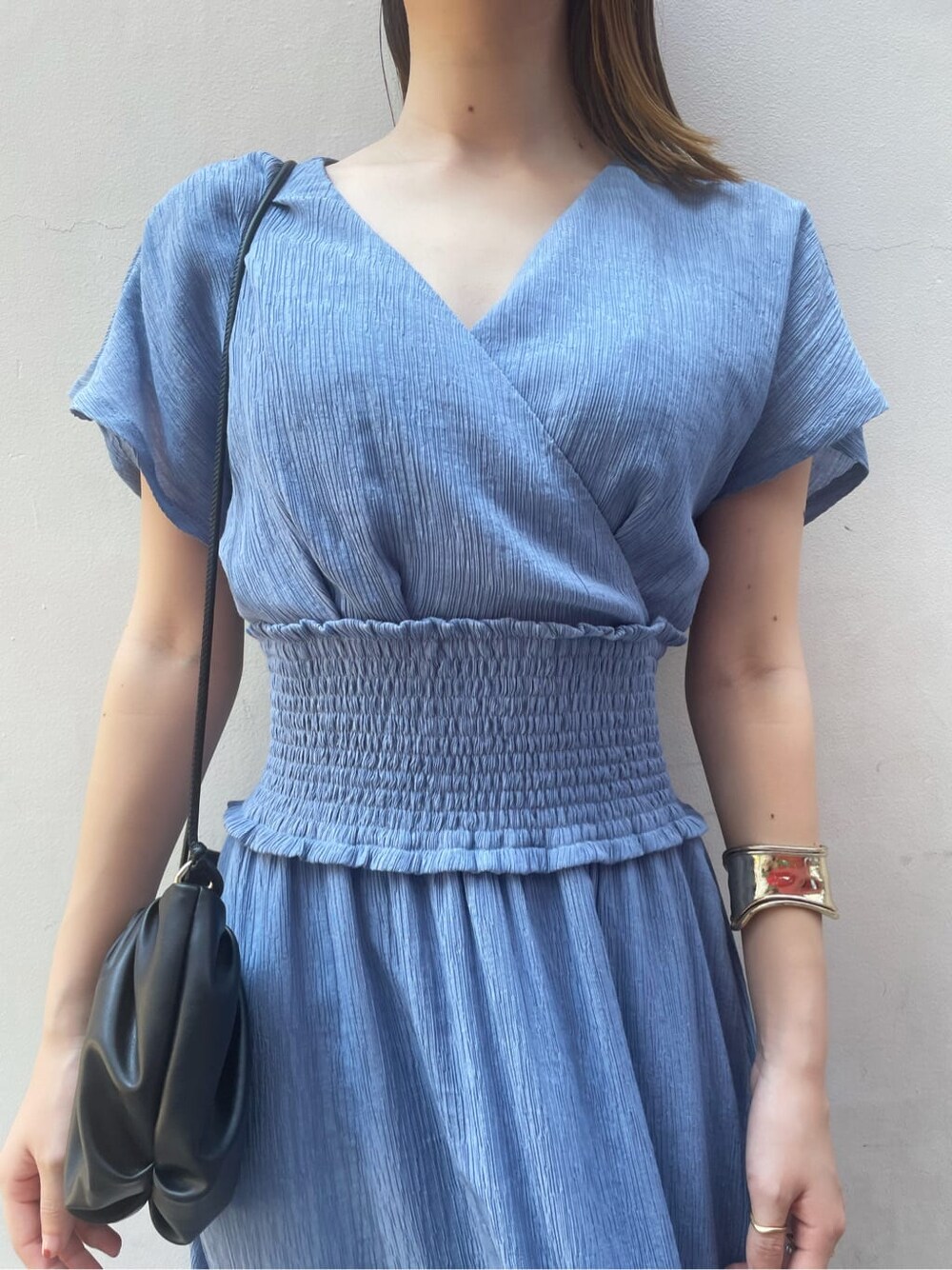 ブラック系のハンドバッグ、ブラック系のサンダル、ブルー系のワンピースを着用したレディースの夏コーディネートの5枚目の写真