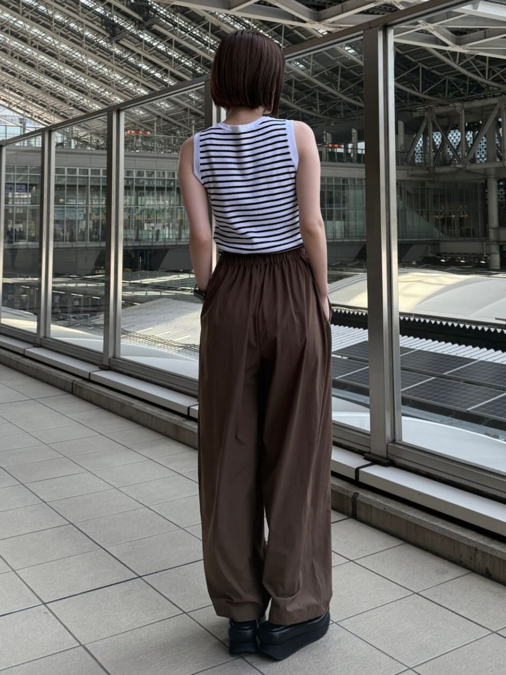 ブラック系のサンダル、ホワイト系のニット/セーター、ブラウン系のその他パンツを着用したレディースの夏コーディネートの3枚目の写真