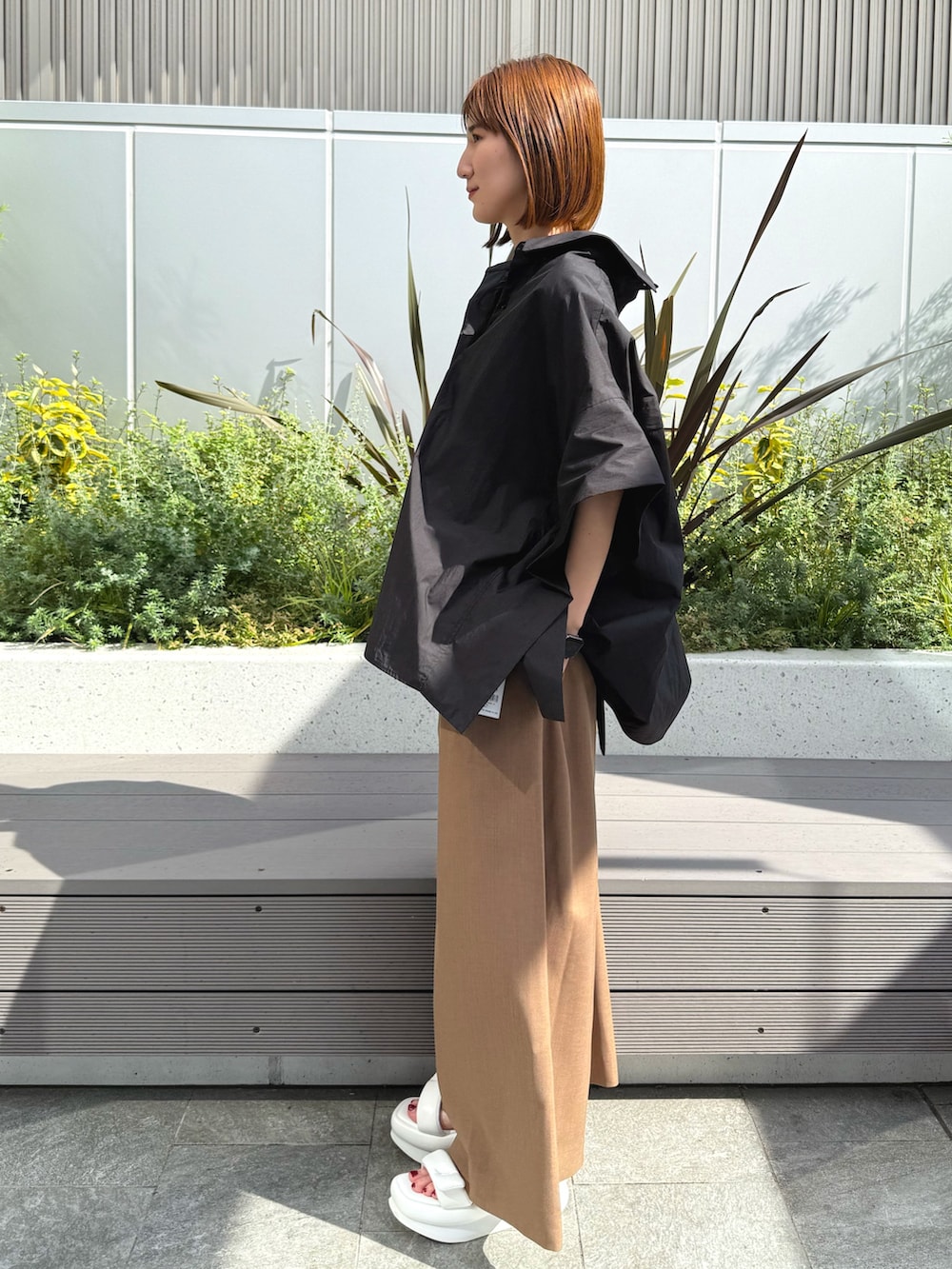 ブラック系のシャツ/ブラウス、ベージュ系のつなぎ/オールインワン、ホワイト系のサンダルを着用したレディースの春コーディネートの3枚目の写真