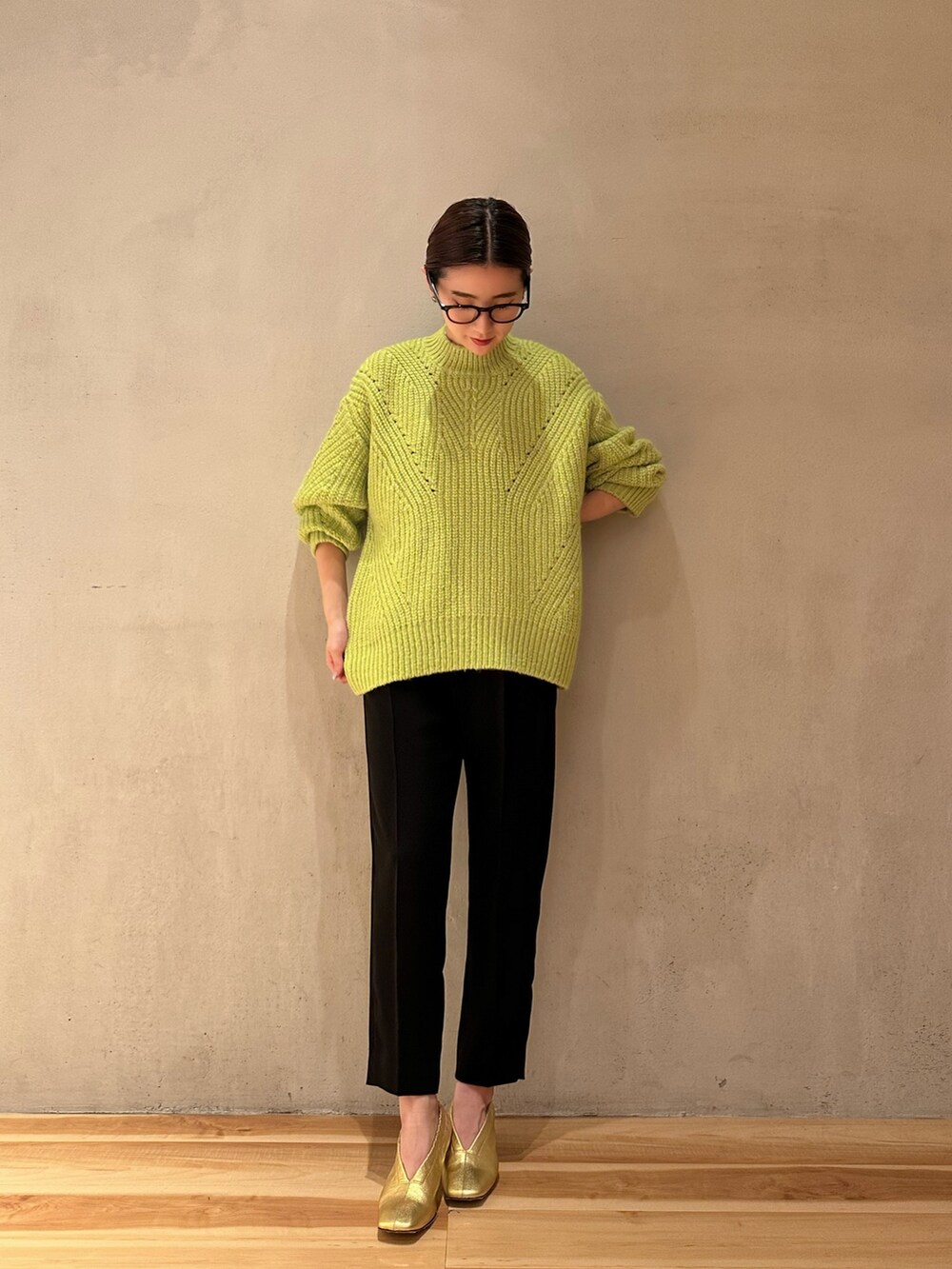 イエロー系のカーディガン/ボレロ、ブラック系のその他パンツ、グリーン系のニット/セーターを着用したレディースの冬コーディネートの4枚目の写真