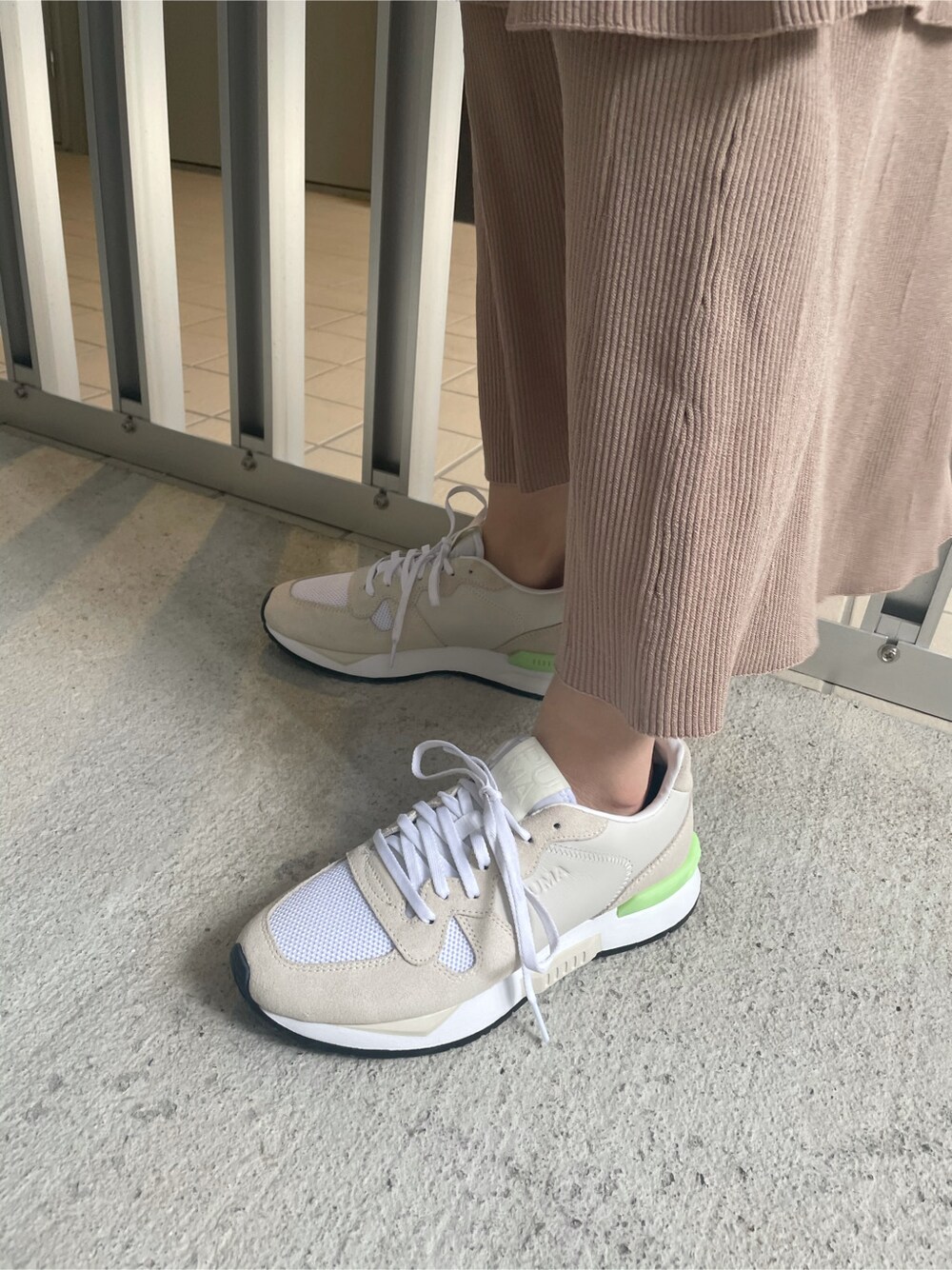 ホワイト系のスニーカー、ベージュ系のスカート、ホワイト系のTシャツ/カットソーを着用したレディースの春コーディネートの6枚目の写真