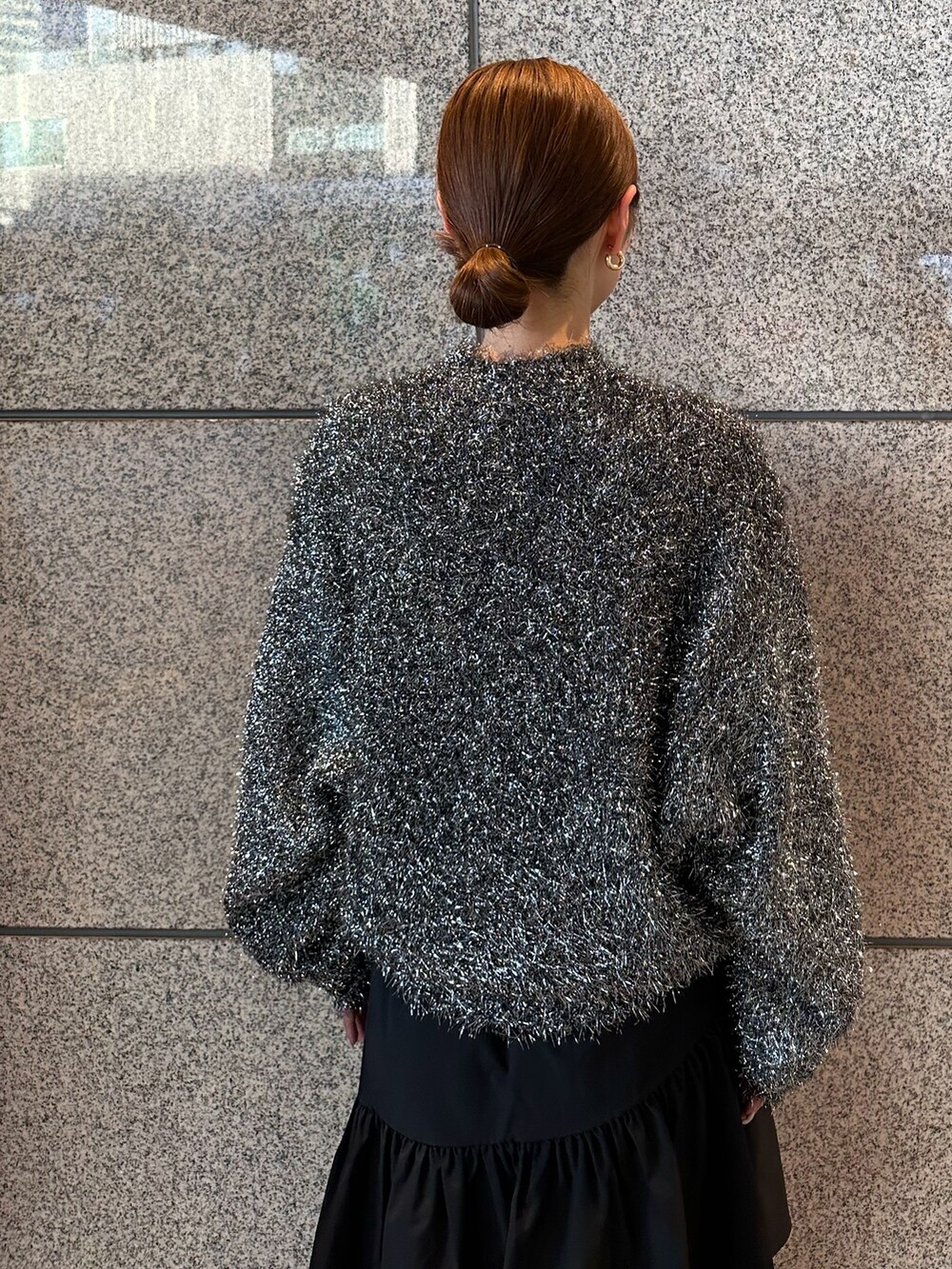 ブラック系のニット/セーター、ブラック系のスカートを着用したレディースの秋コーディネートの5枚目の写真