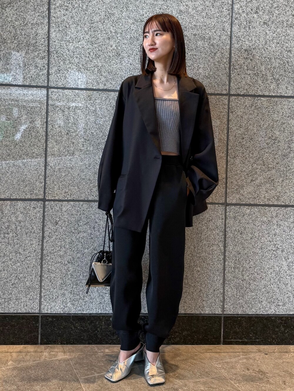 ブラック系のテーラードジャケット、ブラック系のその他パンツ、ブラック系のショルダーバッグを着用したレディースの冬コーディネートの2枚目の写真