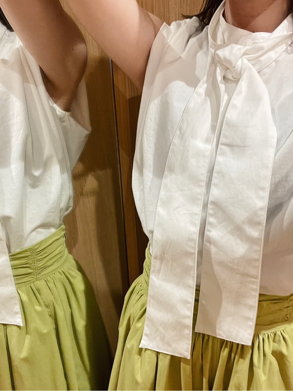 ブラウン系のパンプス、ホワイト系のシャツ/ブラウス、グリーン系のスカートを着用したレディースの夏コーディネートの2枚目の写真