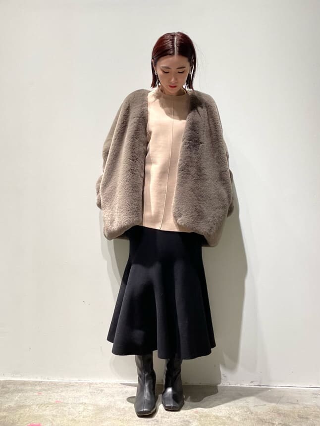 ベージュ系のニット/セーター、ブラウン系のノーカラーコート、ブラック系のブーツを着用したレディースの秋コーディネートの5枚目の写真