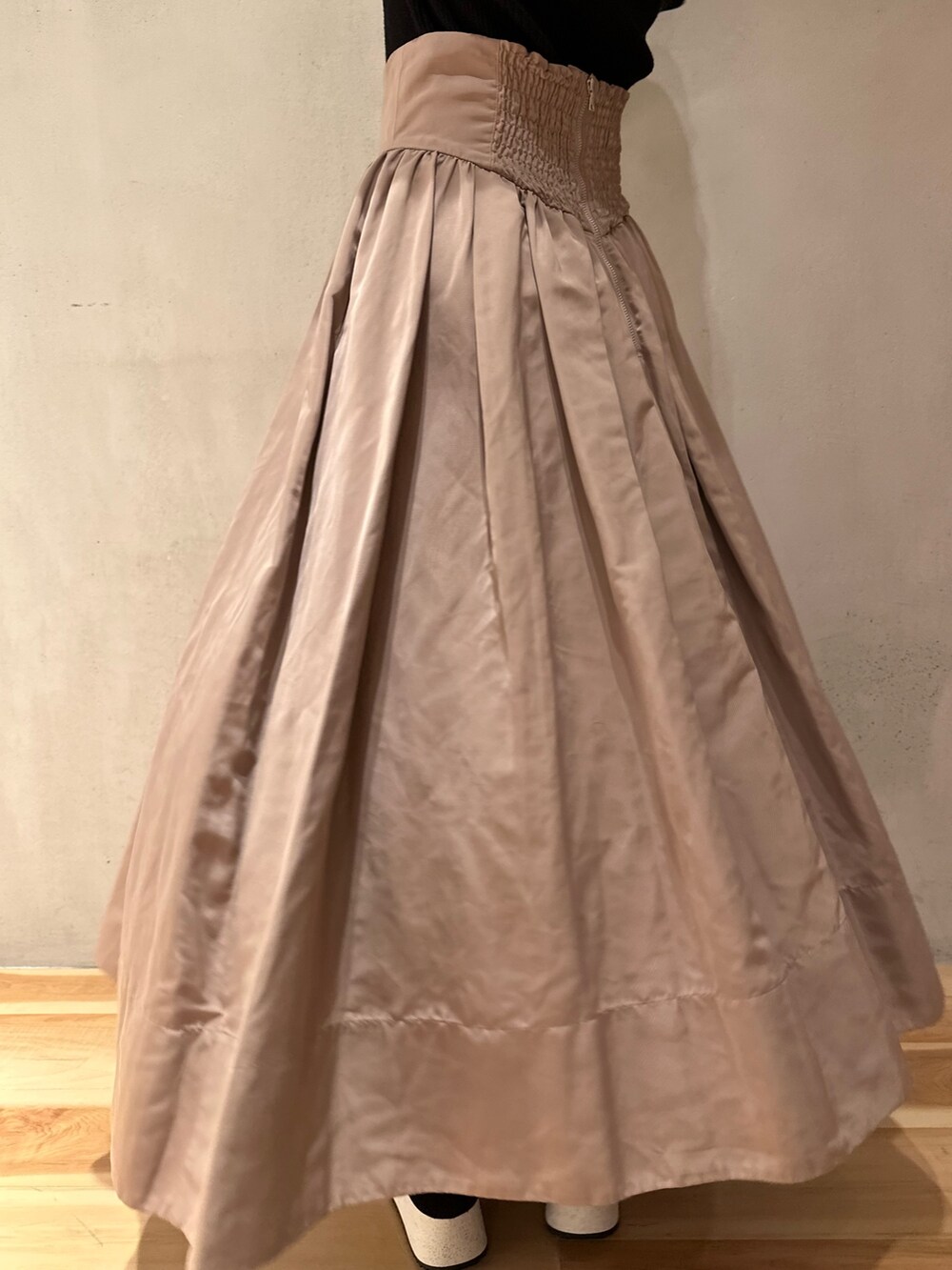 ブラック系のニット/セーター、ベージュ系のスカート、ブラック系のスニーカーを着用したレディースの冬コーディネートの8枚目の写真