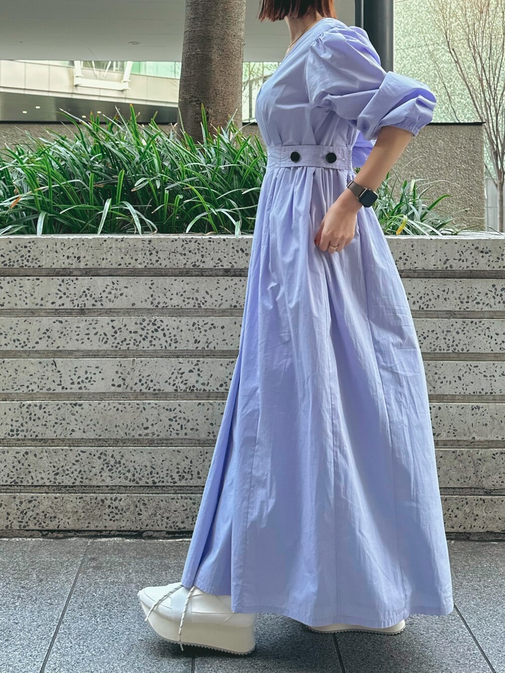 ホワイト系のハンドバッグ、ホワイト系のスニーカー、ブルー系のワンピースを着用したレディースの冬コーディネートの3枚目の写真