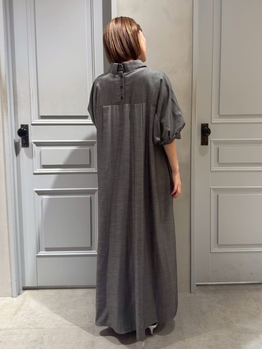 ブラック系のパンプス、グレー系のワンピースを着用したレディースの春コーディネートの5枚目の写真