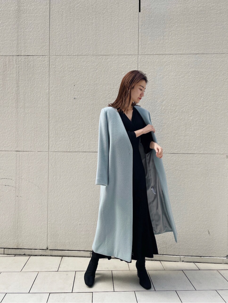 ブルー系のノーカラーコート、ブラック系のワンピースを着用したレディースの冬コーディネートの6枚目の写真