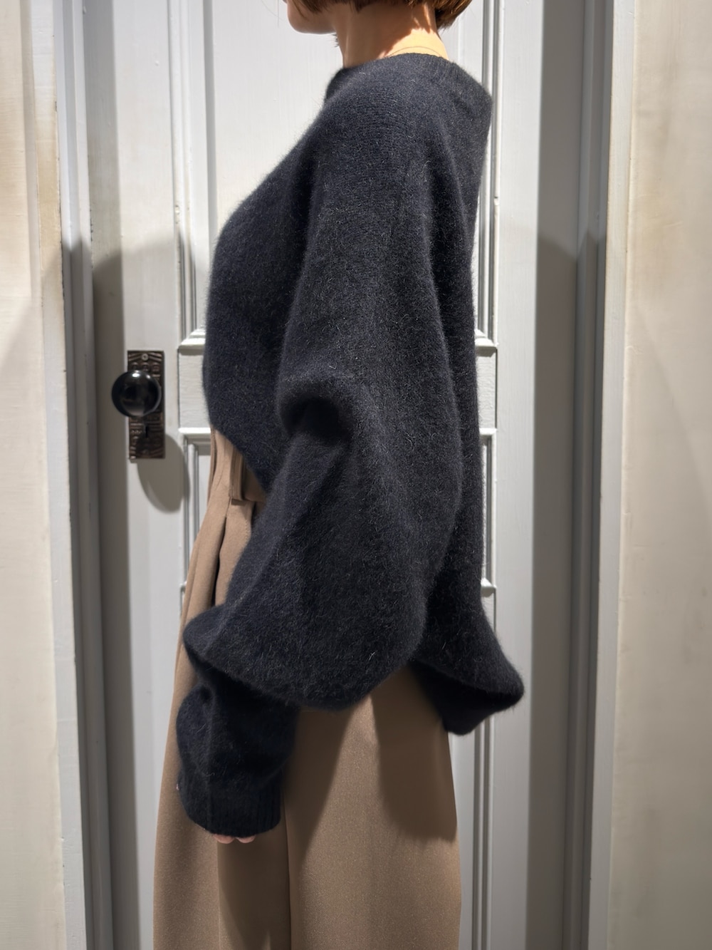 ブラック系のニット/セーター、ベージュ系のその他パンツ、その他のパンプスを着用したレディースの冬コーディネートの7枚目の写真