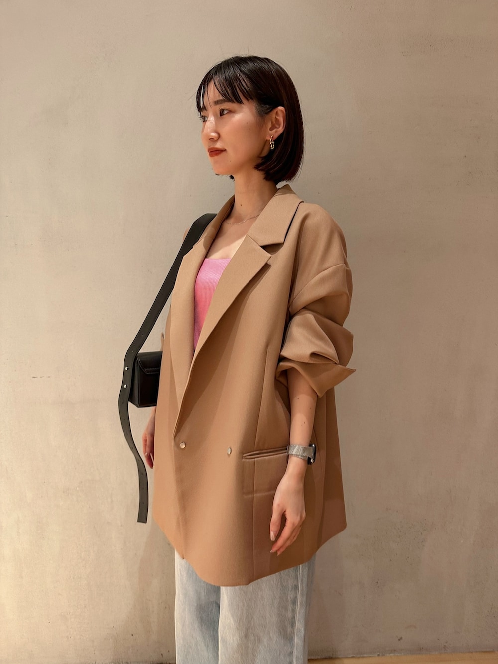 ブルー系のデニムパンツ、ブラック系のパンプス、ブラック系のショルダーバッグを着用したレディースの冬コーディネートの4枚目の写真