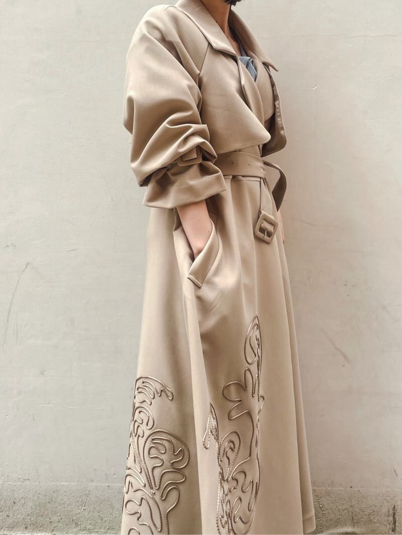 ベージュ系のトレンチコート、ブルー系のワンピース、ホワイト系のサンダルを着用したレディースの春コーディネートの5枚目の写真