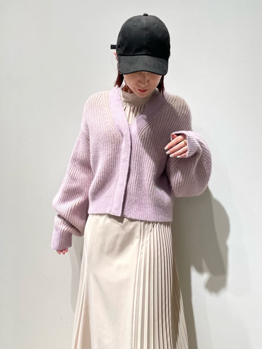 パープル系のカーディガン/ボレロ、ベージュ系のワンピース、ホワイト系のキャップを着用したレディースの秋コーディネートの6枚目の写真