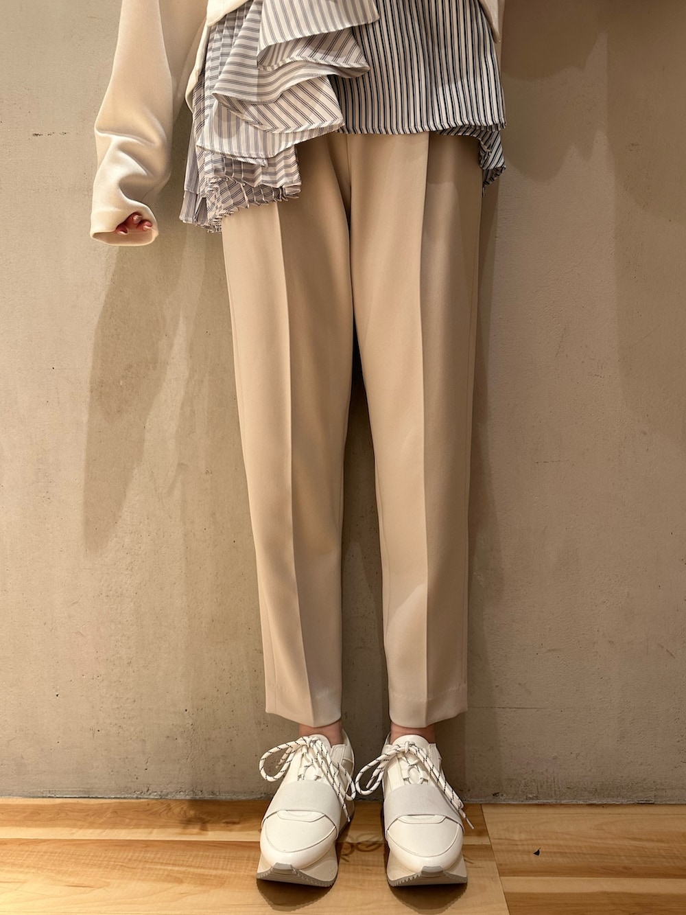 ホワイト系のスニーカー、ブラック系のハンドバッグ、グレー系のその他パンツを着用したレディースの冬コーディネートの6枚目の写真