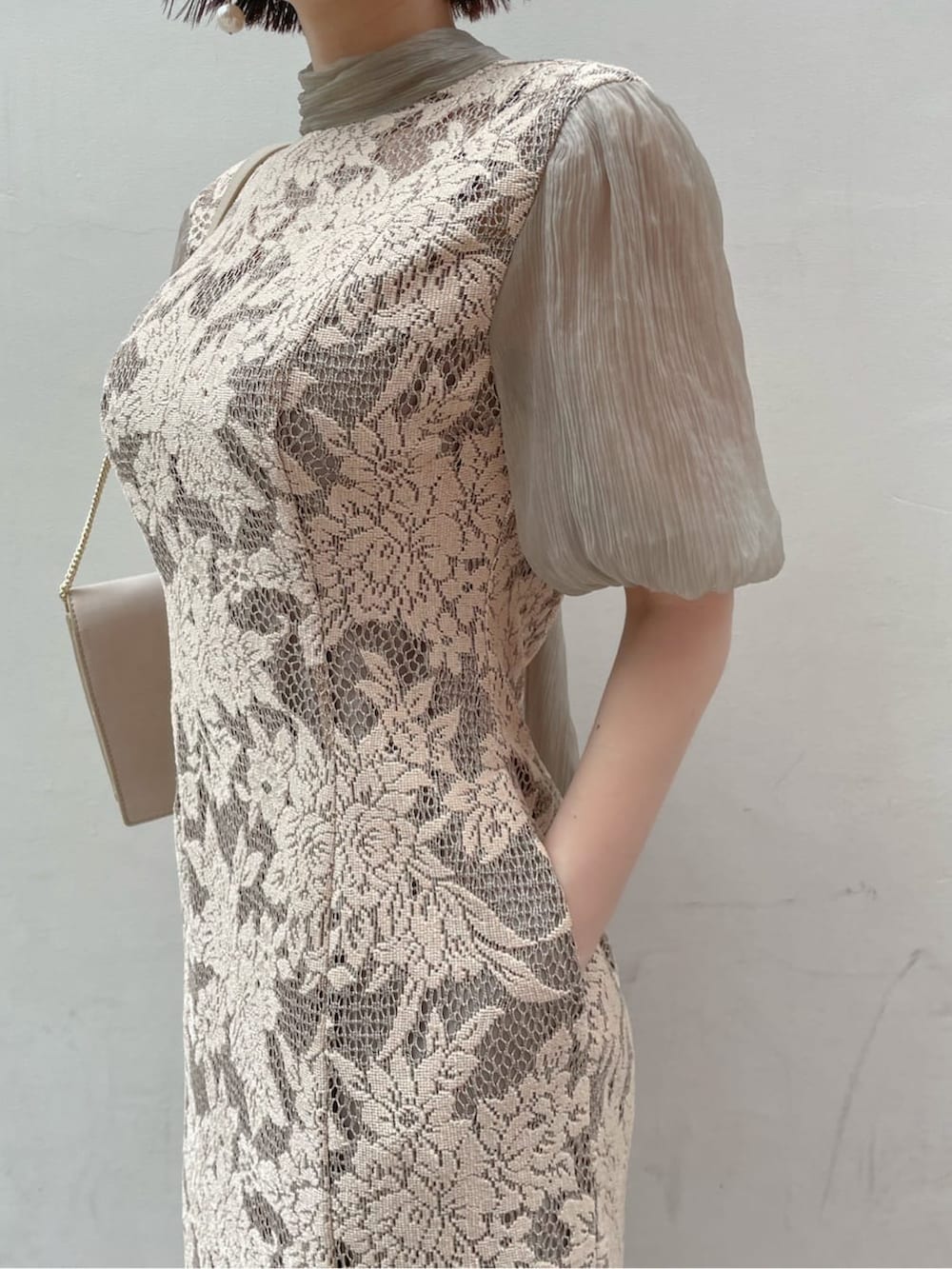 ベージュ系のドレス、ゴールド系のパンプス、ベージュ系のクラッチバッグを着用したレディースの夏コーディネートの5枚目の写真