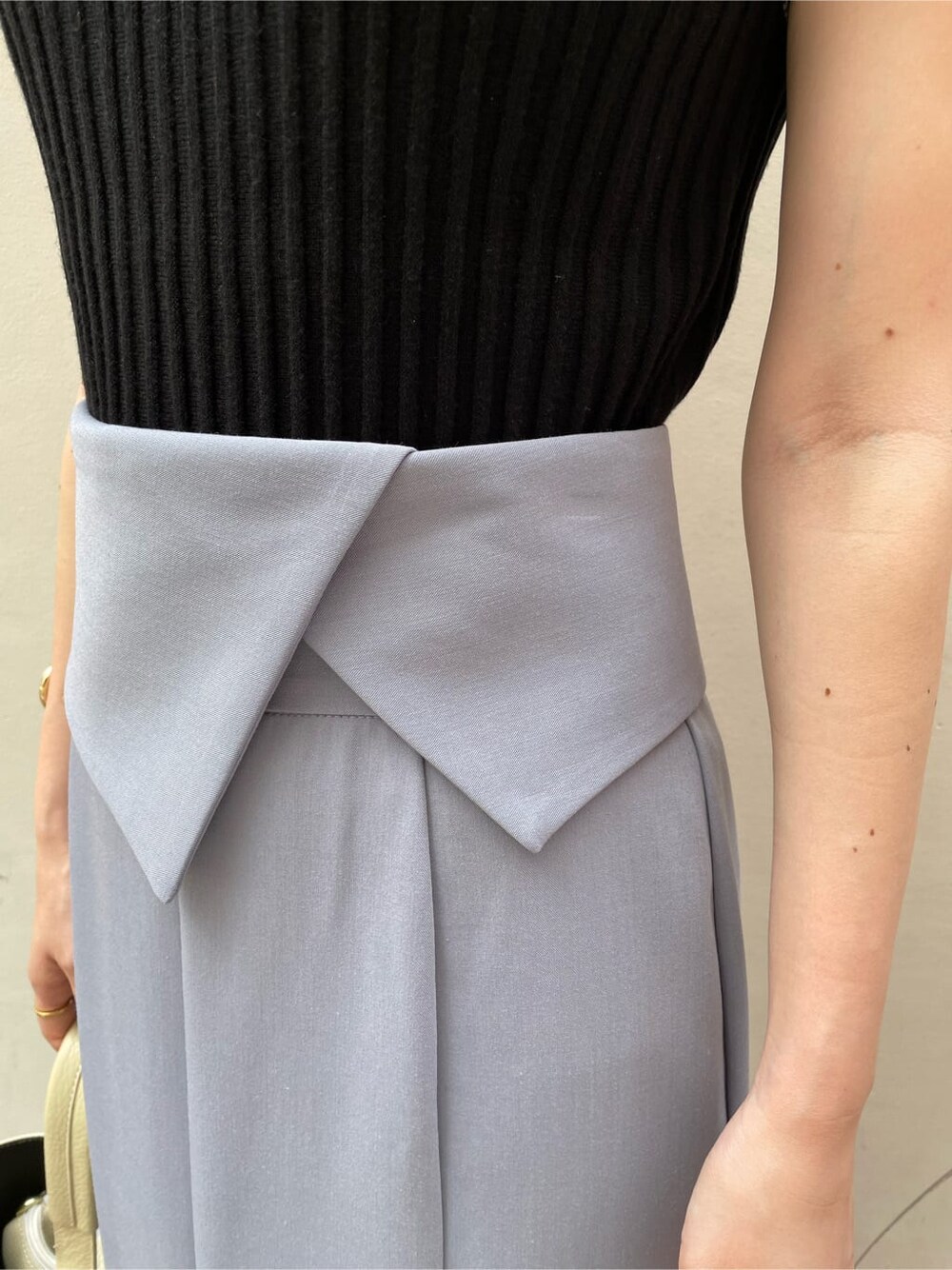 ブルー系のスカート、ブラック系のニット/セーターを着用したレディースの夏コーディネートの6枚目の写真