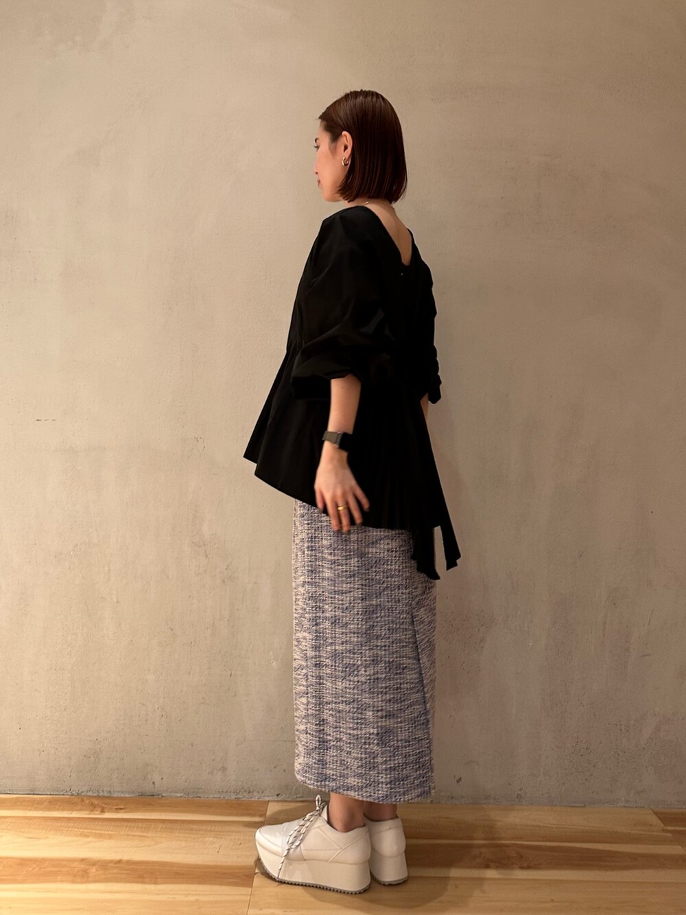 ブラック系のシャツ/ブラウス、ホワイト系のスニーカー、ブルー系のスカートを着用したレディースの春コーディネートの7枚目の写真