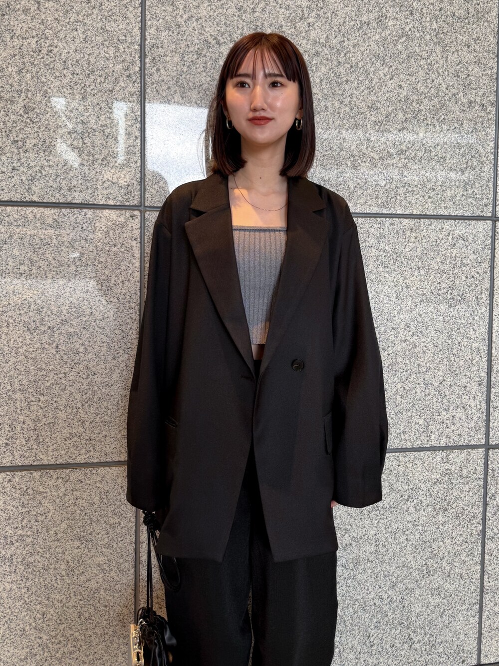 ブラック系のテーラードジャケット、ブラック系のその他パンツ、ブラック系のショルダーバッグを着用したレディースの冬コーディネートの3枚目の写真