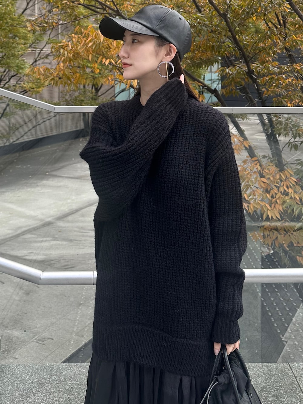 ブラック系のワンピース、ブラック系のショルダーバッグ、ブラック系のキャップを着用したレディースの秋コーディネートの6枚目の写真