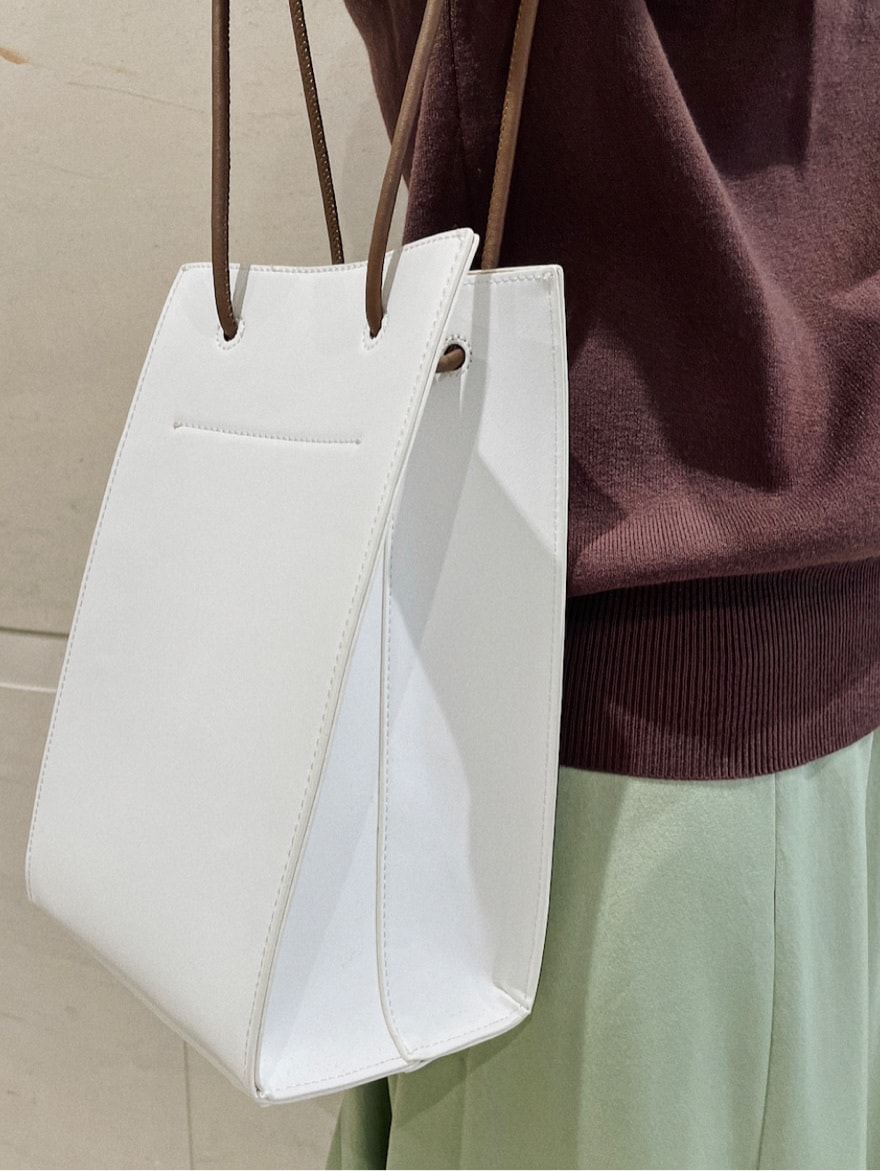 その他のパンプス、グリーン系のスカート、ホワイト系のハンドバッグを着用したレディースの冬コーディネートの5枚目の写真