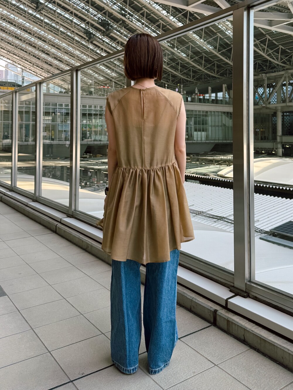 イエロー系のシャツ/ブラウス、ブルー系のデニムパンツを着用したレディースの夏コーディネートの4枚目の写真