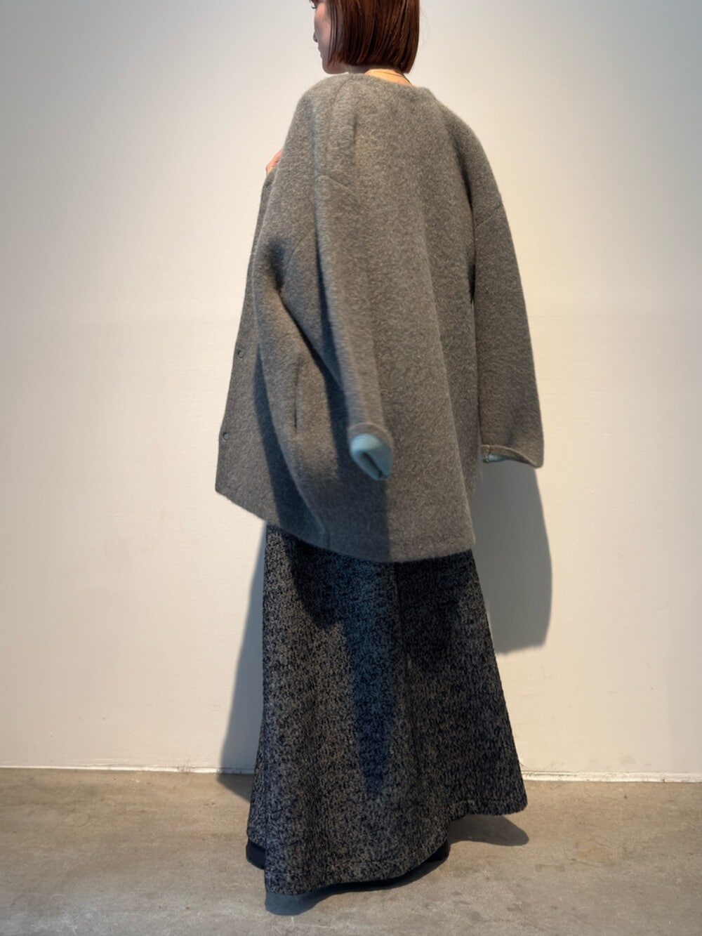 ブラック系のワンピース、グレー系のカーディガン/ボレロを着用したレディースの秋コーディネートの7枚目の写真