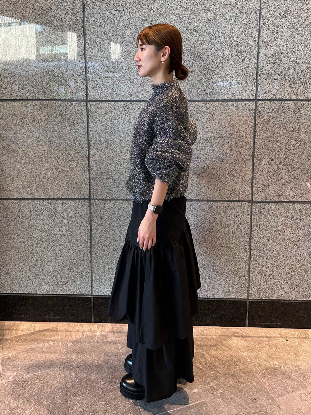 ブラック系のニット/セーター、ブラック系のスカートを着用したレディースの秋コーディネートの2枚目の写真