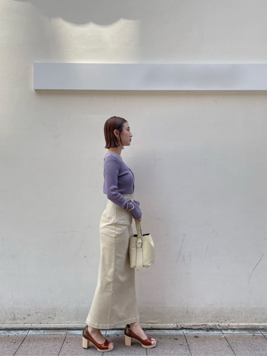 ブラウン系のパンプス、ベージュ系のスカート、パープル系のニット/セーターを着用したレディースの夏コーディネートの7枚目の写真