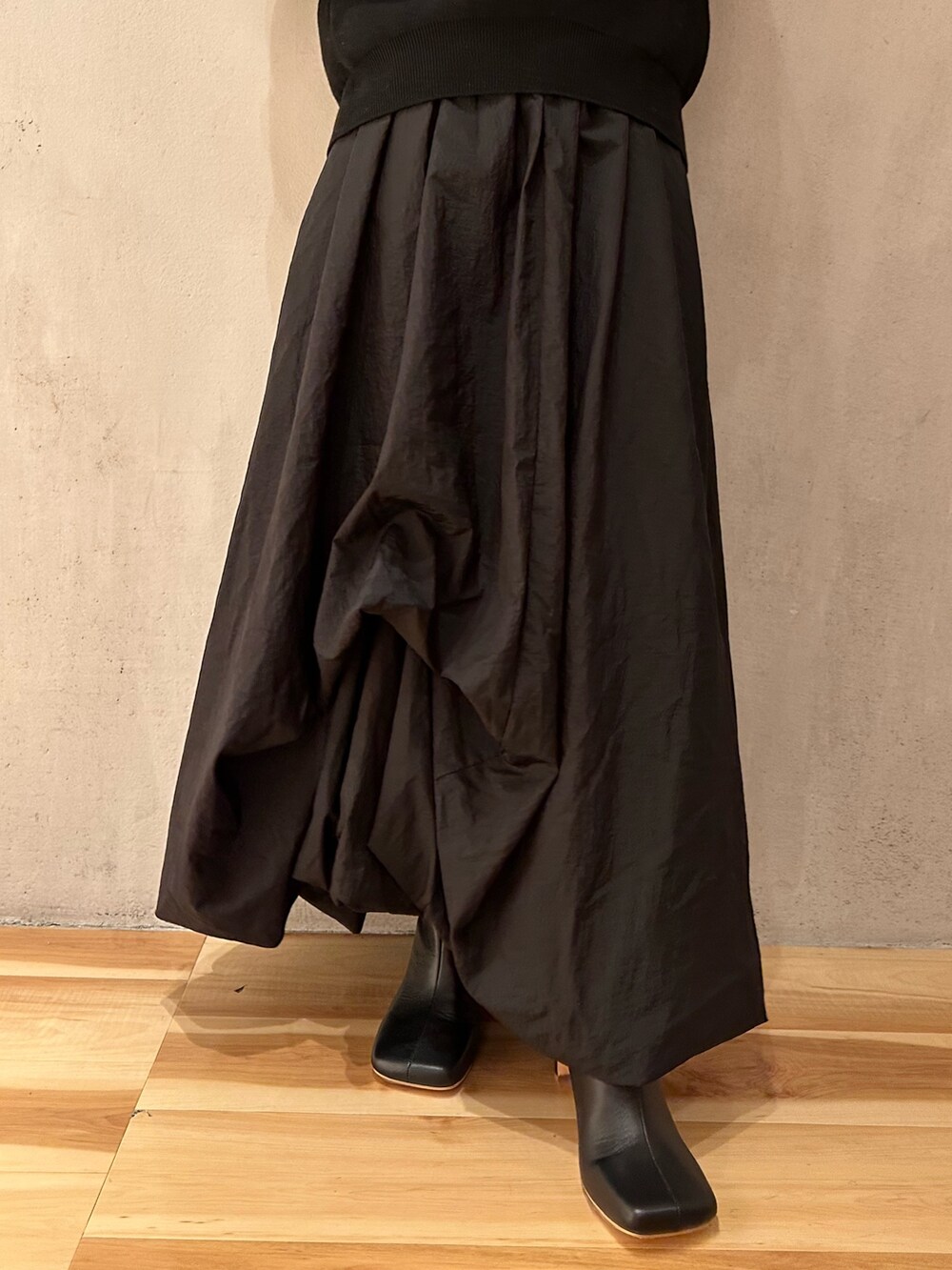 ブラック系のニット/セーター、ブラック系のブーツ、ピンク系のノーカラージャケットを着用したレディースの夏コーディネートの7枚目の写真