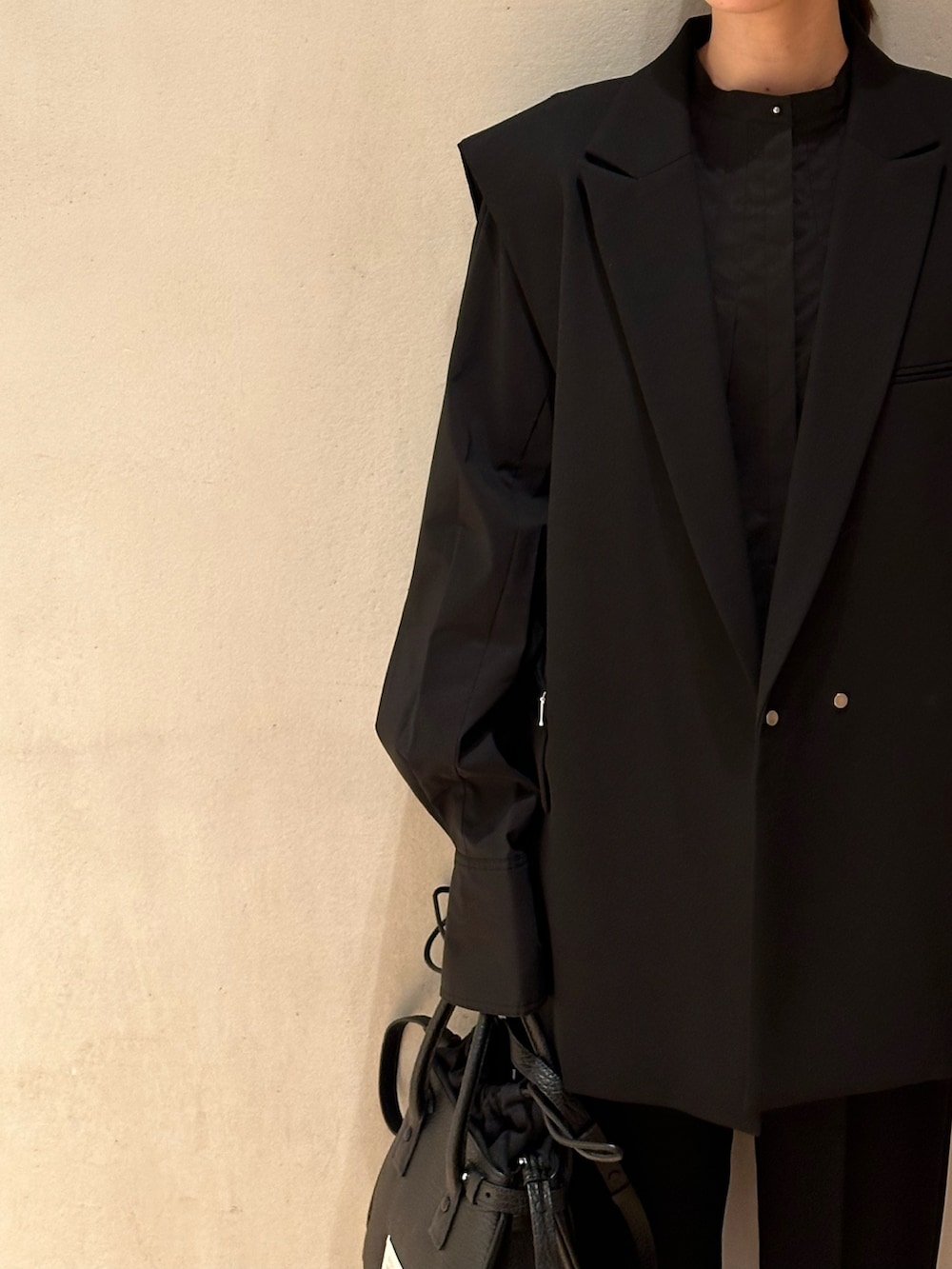 ブラック系のショルダーバッグ、ブラック系のテーラードジャケット、ブラック系のその他パンツを着用したレディースの春コーディネートの6枚目の写真