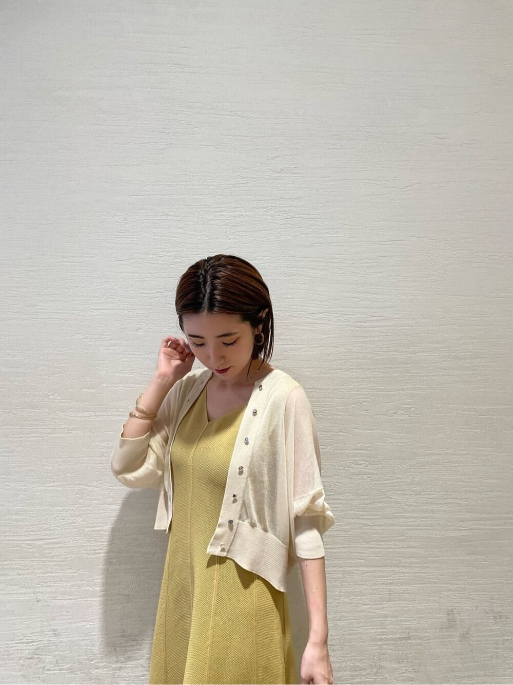 ホワイト系のサンダル、イエロー系のワンピース、ホワイト系のカーディガン/ボレロを着用したレディースの夏コーディネートの5枚目の写真