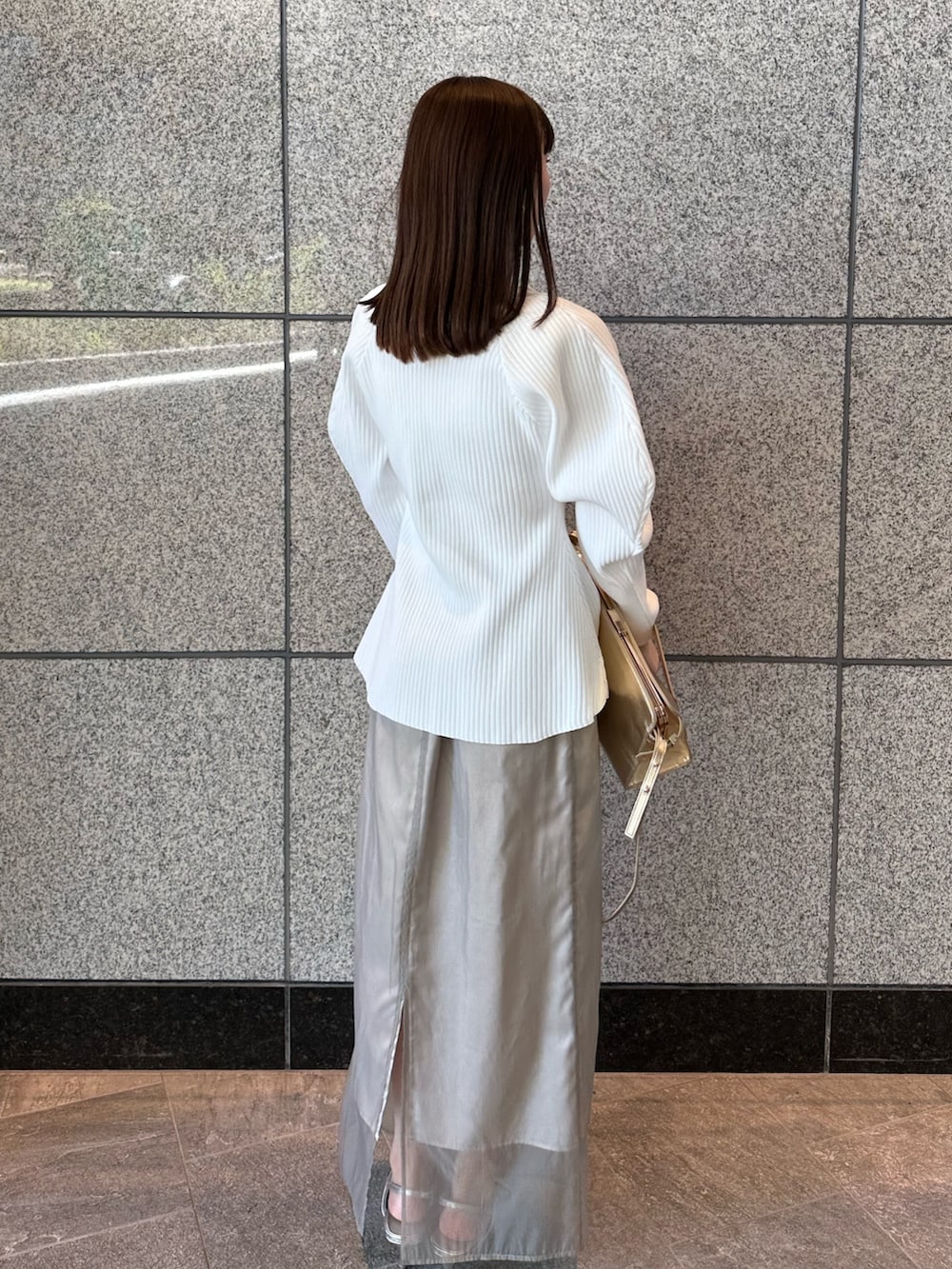 ホワイト系のカーディガン/ボレロ、ベージュ系のスカート、シルバー系のサンダルを着用したレディースの秋コーディネートの5枚目の写真