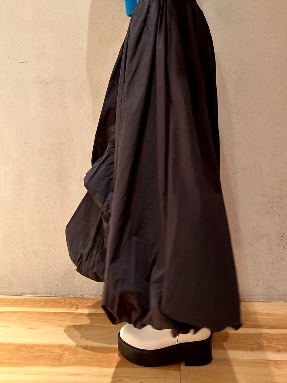 ブラック系のスカート、ブルー系のニット/セーター、ホワイト系のブーツを着用したレディースの冬コーディネートの7枚目の写真