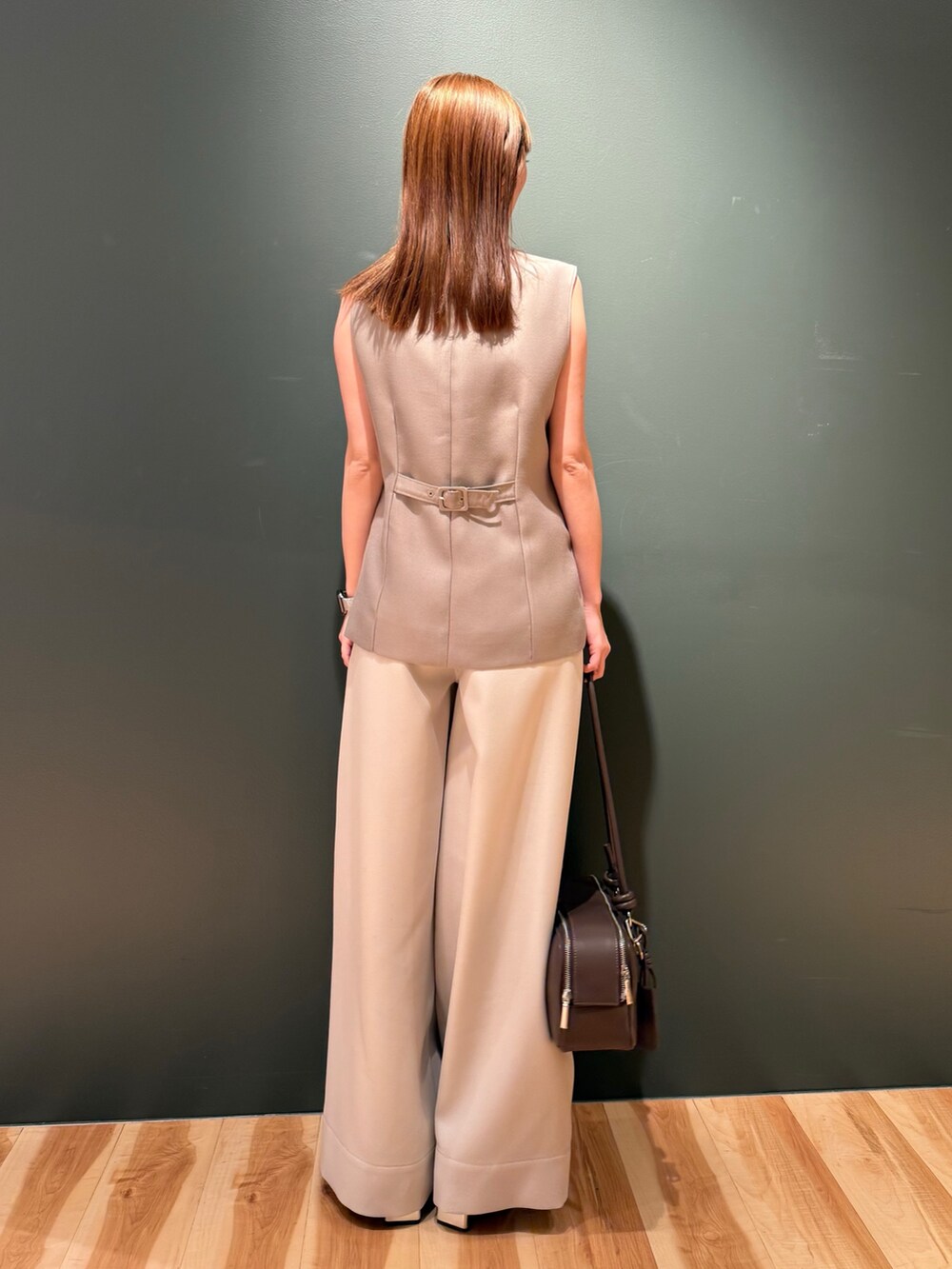 ベージュ系のベスト、ホワイト系のその他パンツ、ブラック系のボストンバッグを着用したレディースの冬コーディネートの4枚目の写真