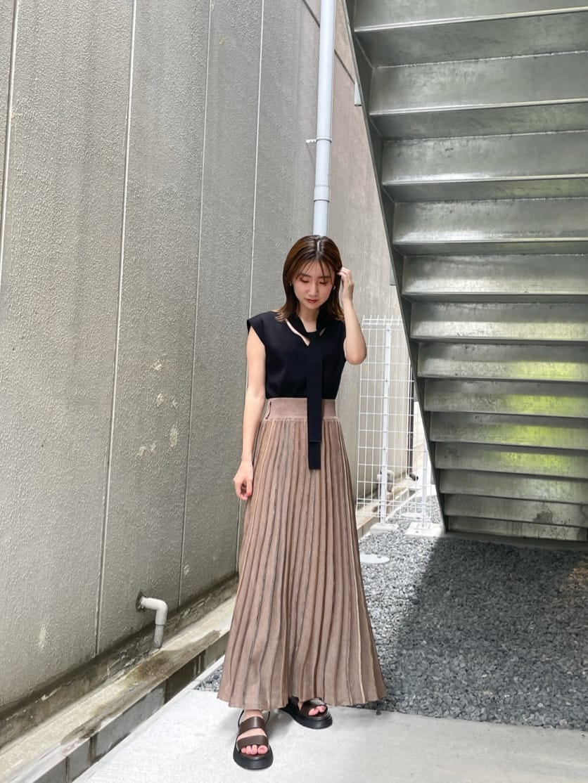 ブラウン系のスカート、ブラック系のニット/セーター、ブラウン系のサンダルを着用したレディースの夏コーディネートの5枚目の写真