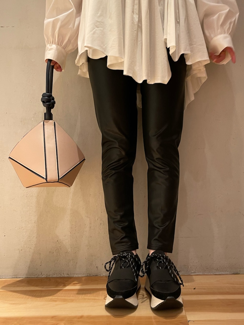 ホワイト系のシャツ/ブラウス、ブラック系のその他パンツ、ベージュ系のハンドバッグを着用したレディースの秋コーディネートの5枚目の写真