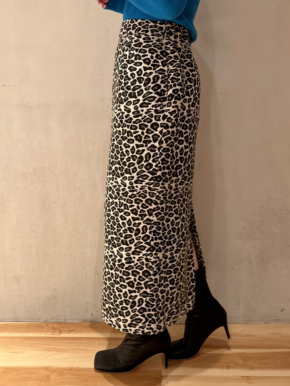 ホワイト系のスカート、ブラック系のブーツ、ブルー系のニット/セーターを着用したレディースの夏コーディネートの5枚目の写真